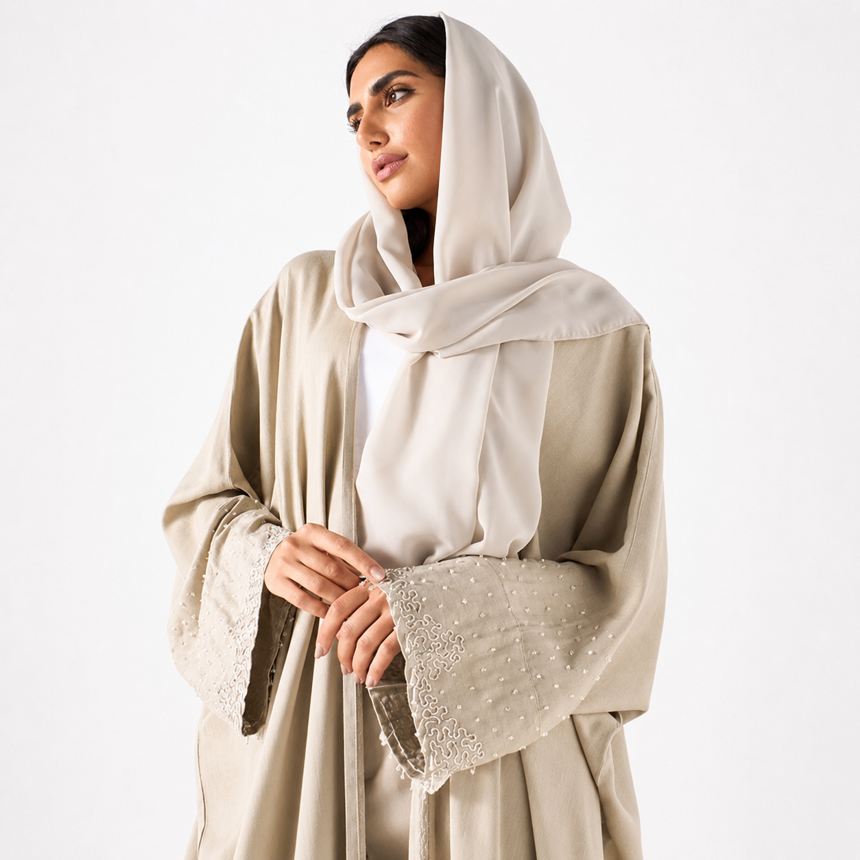 Close-up of pearl embellishments on beige bisht abaya sleeve