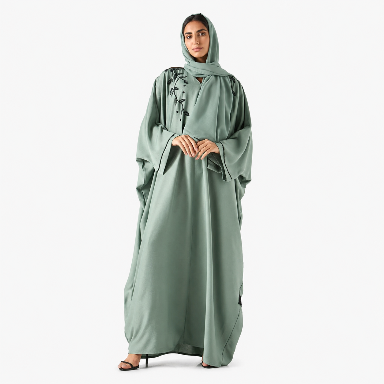 Close-up of black shoulder embroidery on sage green bisht abaya